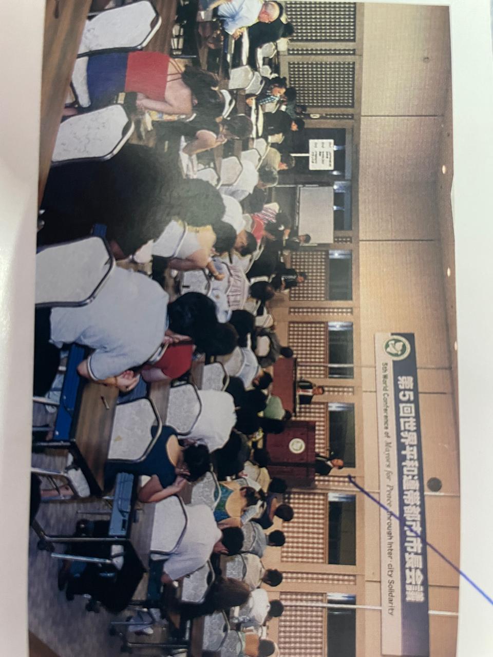 A bright pink sheet of paper used to wrap flowers curves in front of rich blue background